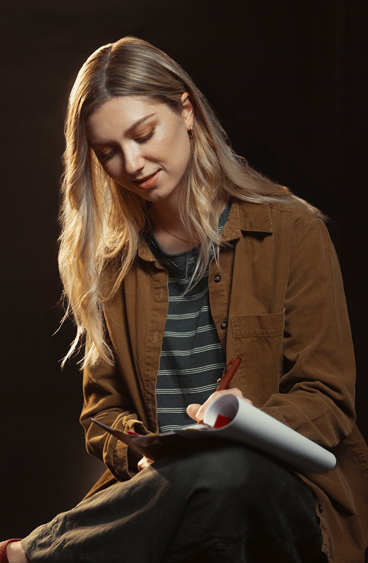 A young performer makes notes in a script.